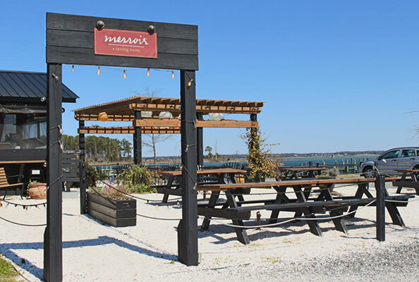 Outdoor seating area on the beach with picnic tables