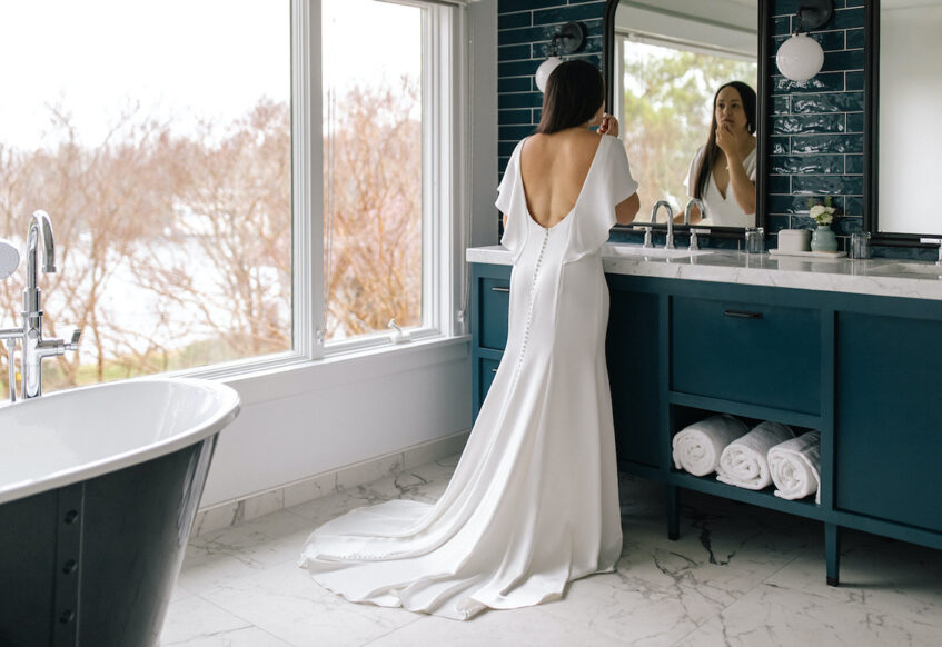 Bride standing in front of the mirror at our classic Tides Inn resort in Irvington, VA